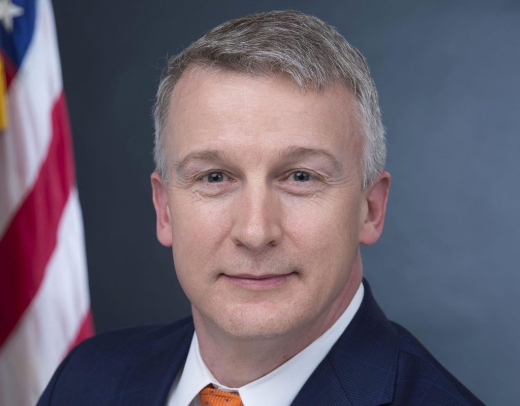 Headshot of Dr Rick Bright with US flag in background