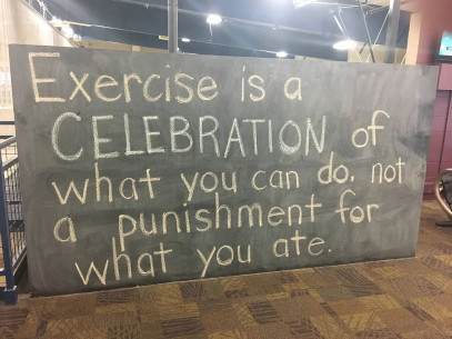 A chalkboard at a gym reads: Exercise is a celebration of what you can do, not a punishment for what you ate.