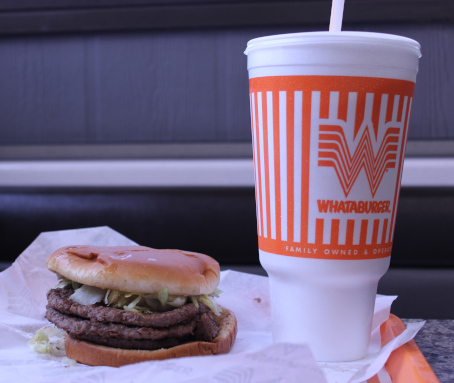 The color photo shows a tray on a table at a Whataburger fast food chain store in Fort Worth, Texas. On the tray sit a large vanilla milkshake (over 900 calories) and a triple meat Whataburger (over 1000 calories). They look disgusting.