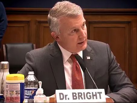 Photo of otherwise admirable whistleblower Dr Bright answering questions for rich powerful politicians instead of the public, and don't even start with civic religion comebacks to that, Boomer!